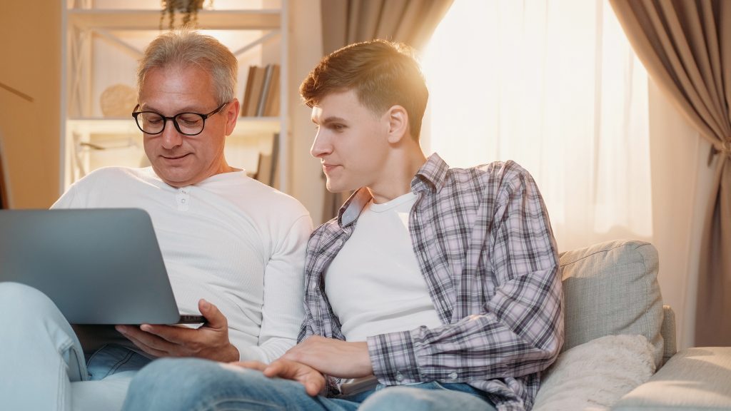 Parent and teen talking at home while looking at a laptop
